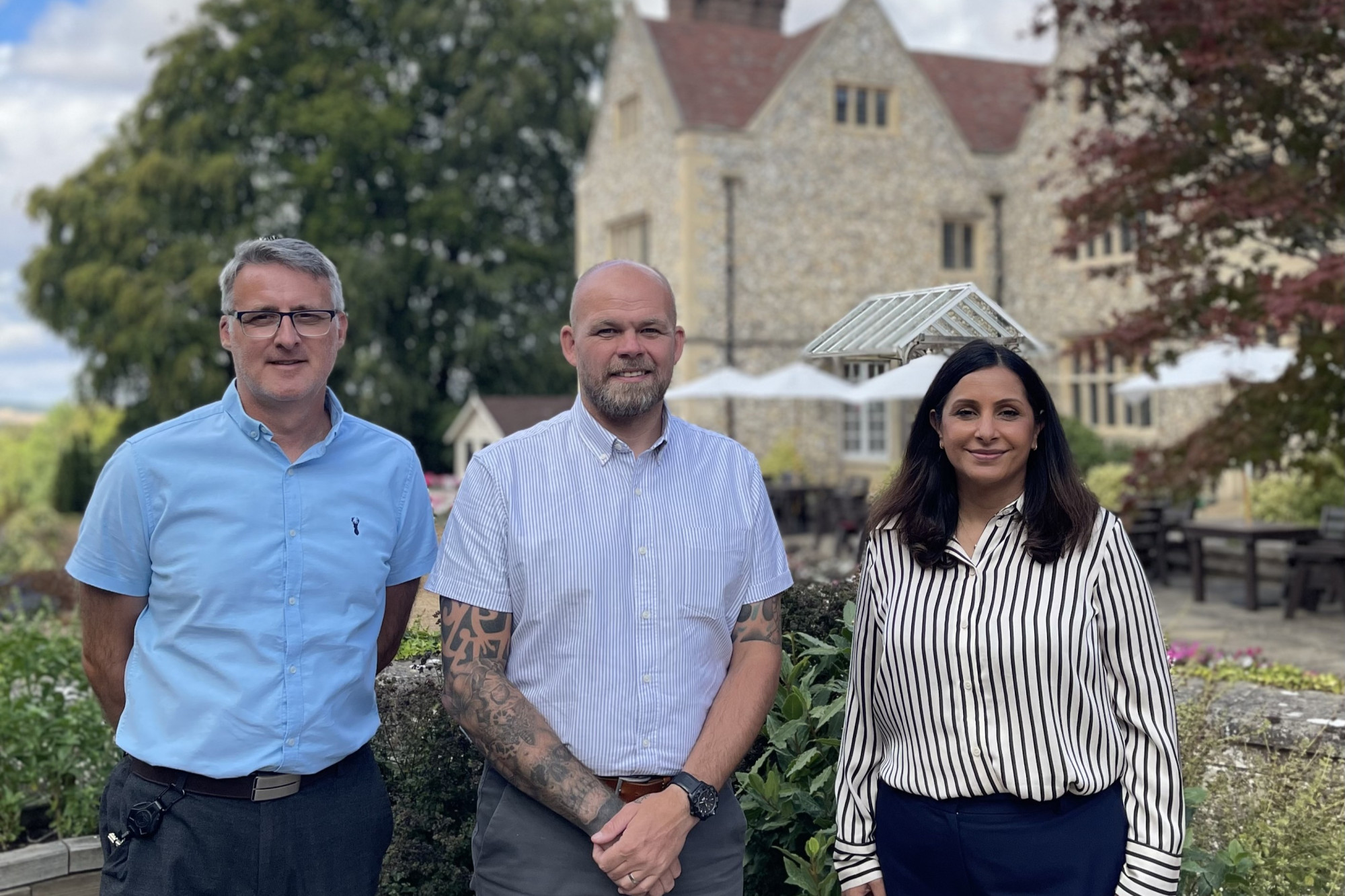 Ian Barron (left) and Julie Pink (right) from Flint House are pictured with Darren Adams (centre) outside the facility in Goring-on-Thames